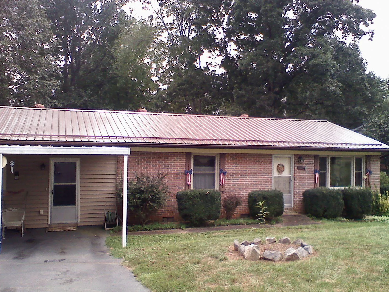 Bronze metal roof and carport on a brick ranch home — Roof Repair work by our crew in Landrum